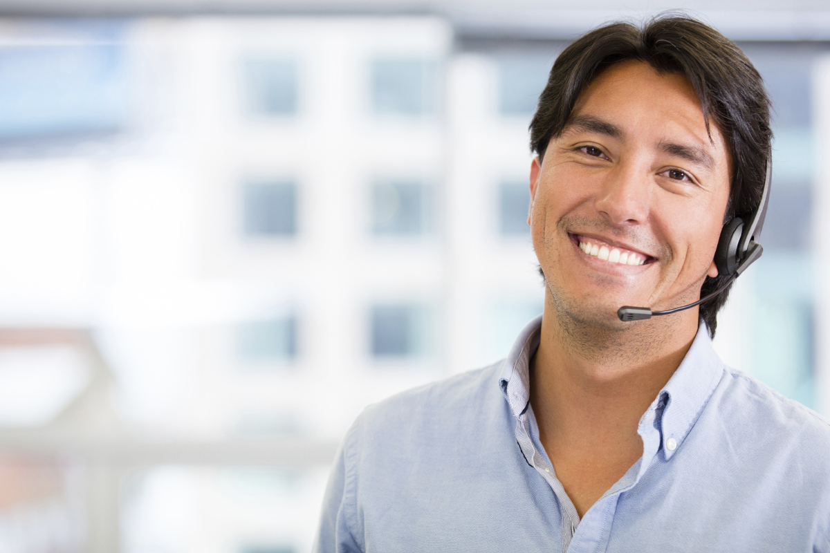 A smiling person wearing an office phone headset