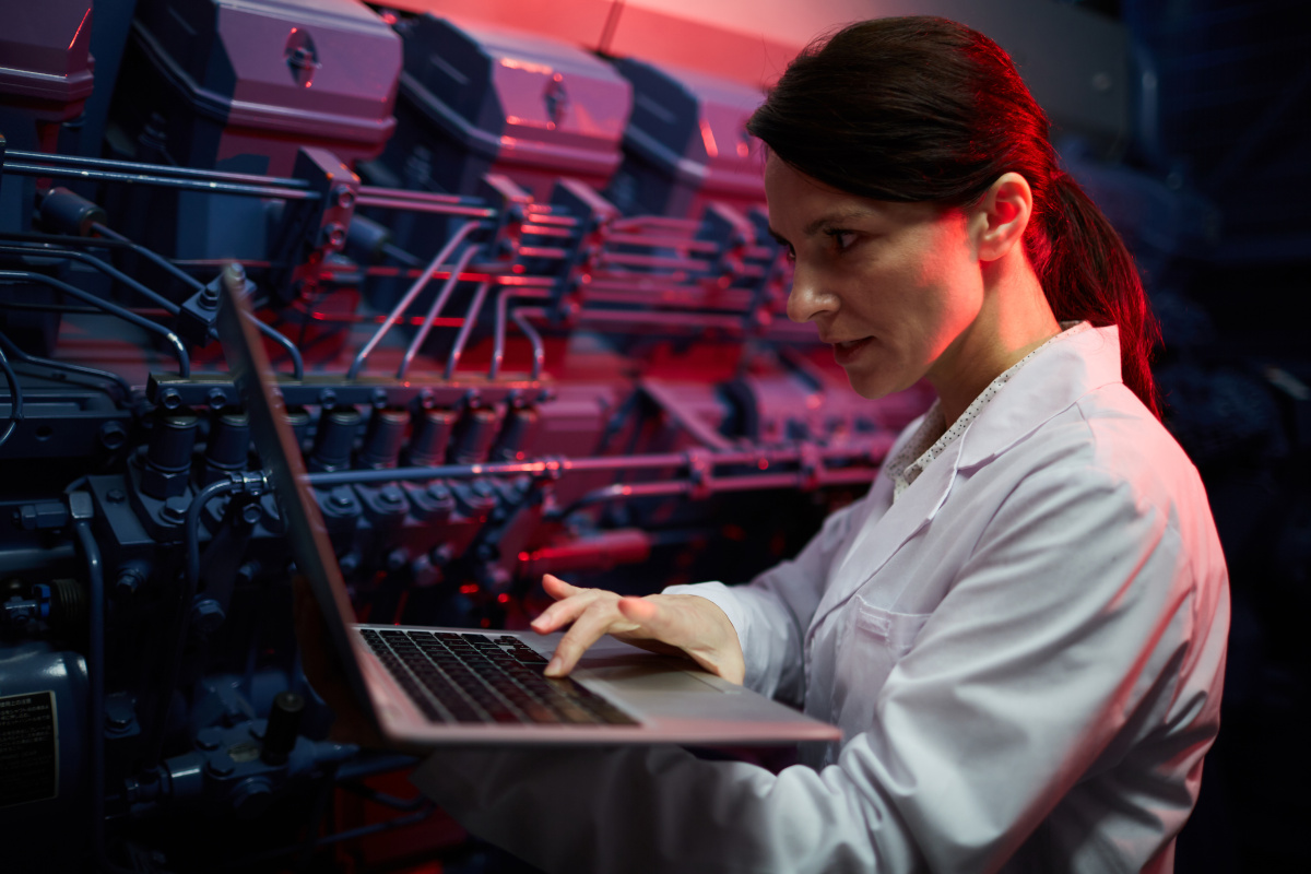 A woman using a laptop in a server room