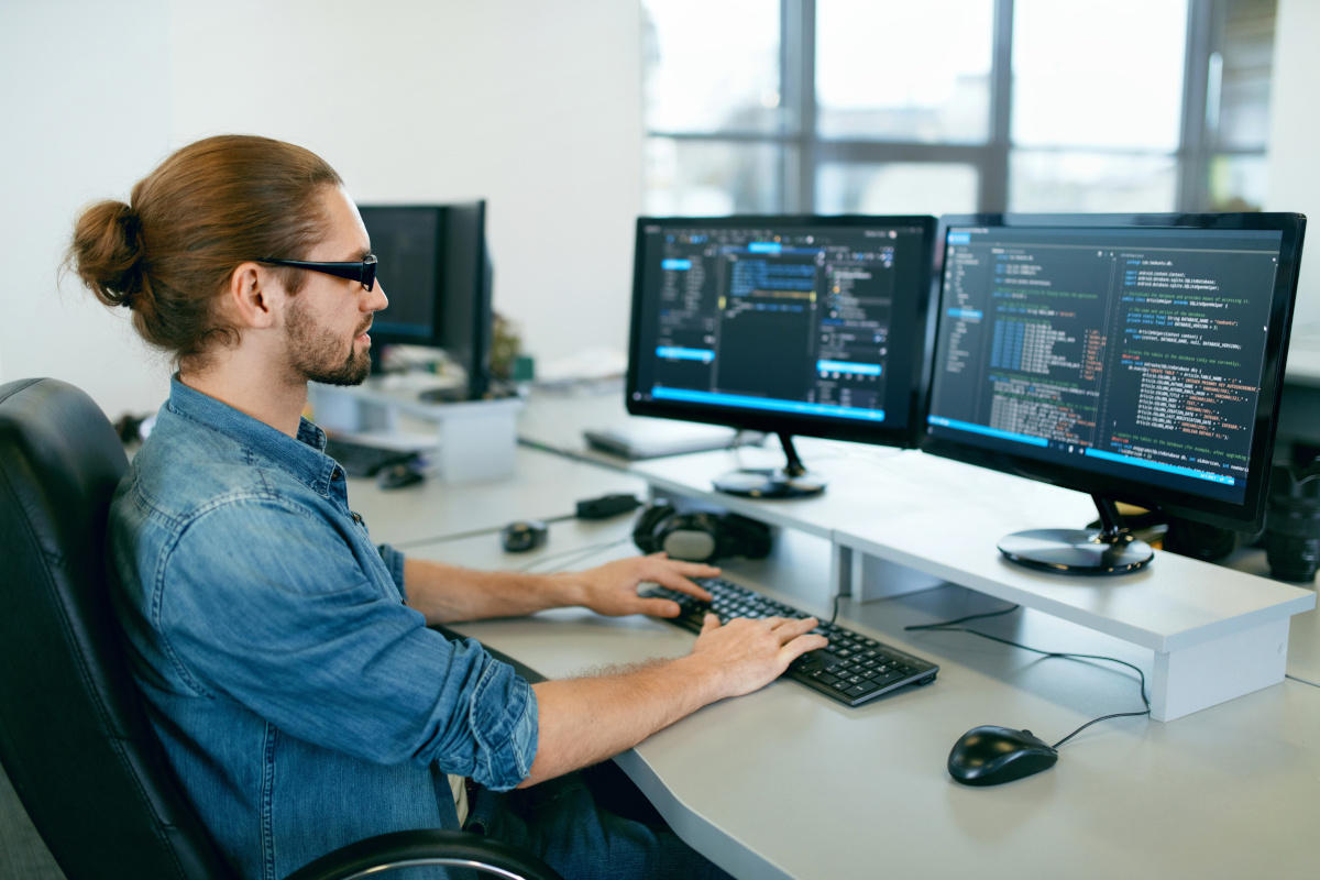 Men writing code on computer