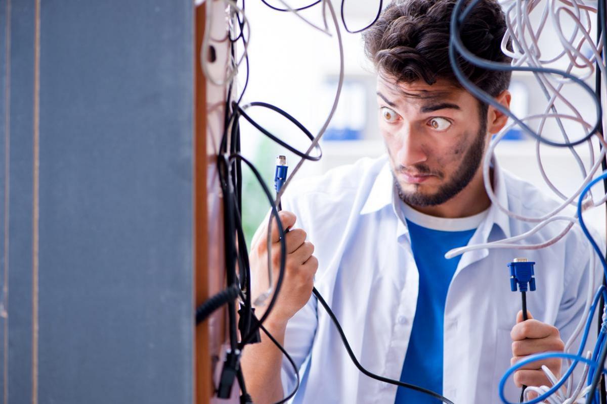 Technician untangling a disorganized bundle of cables.