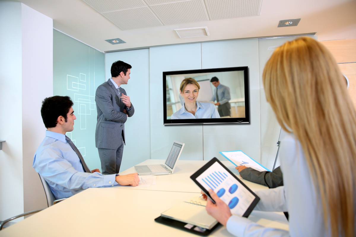 A group of three people on a conference video call with two other people