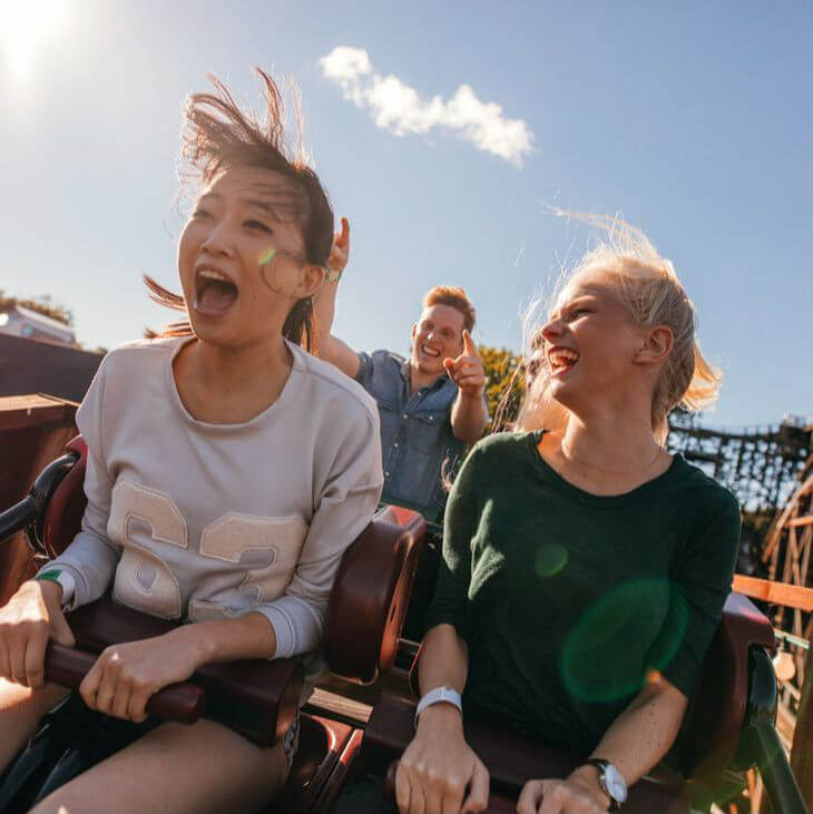 Two Women Laughing While Riding in the Car of a Roller Coaster